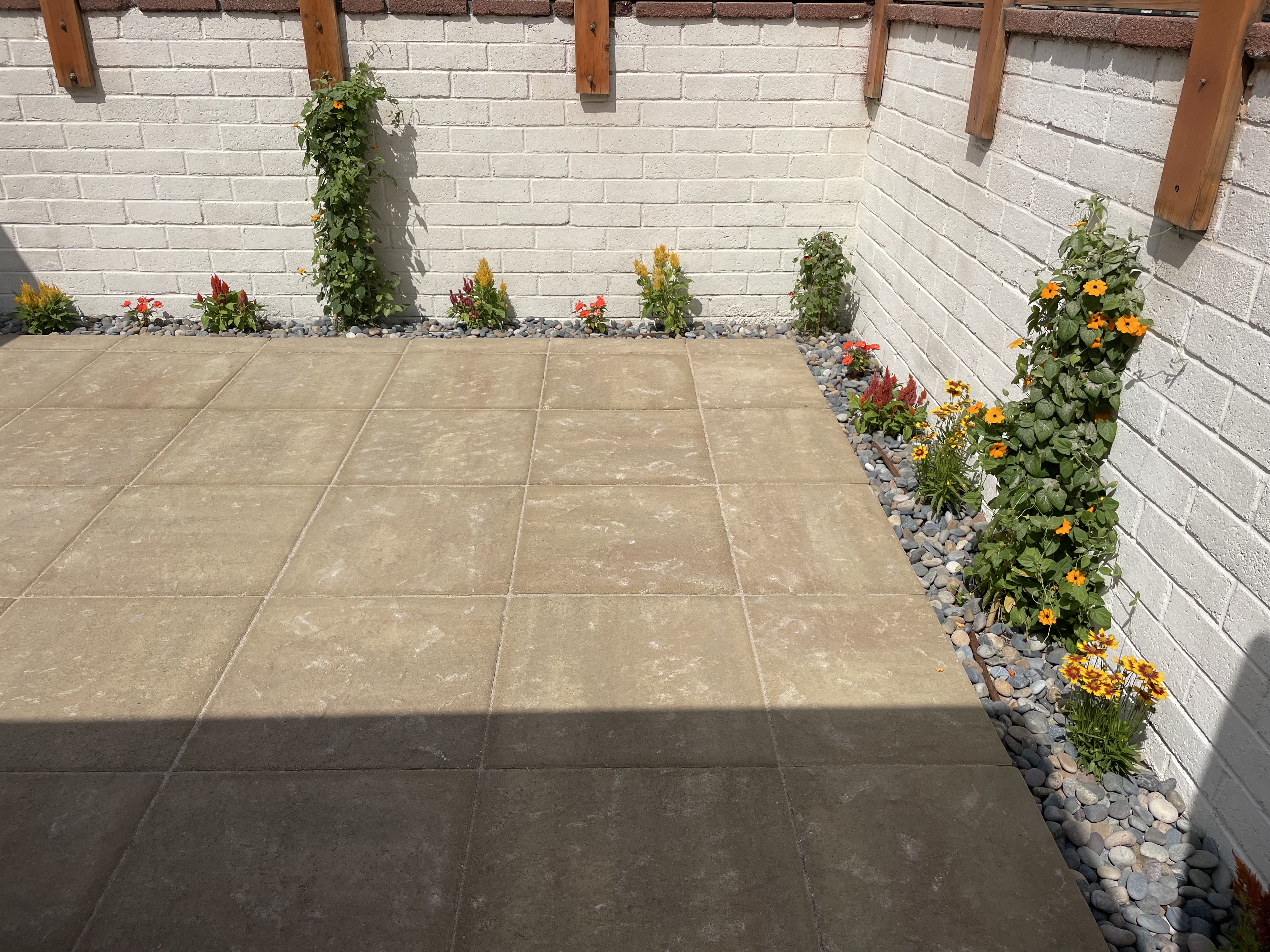 A outdoor patio space with rocks and bushes