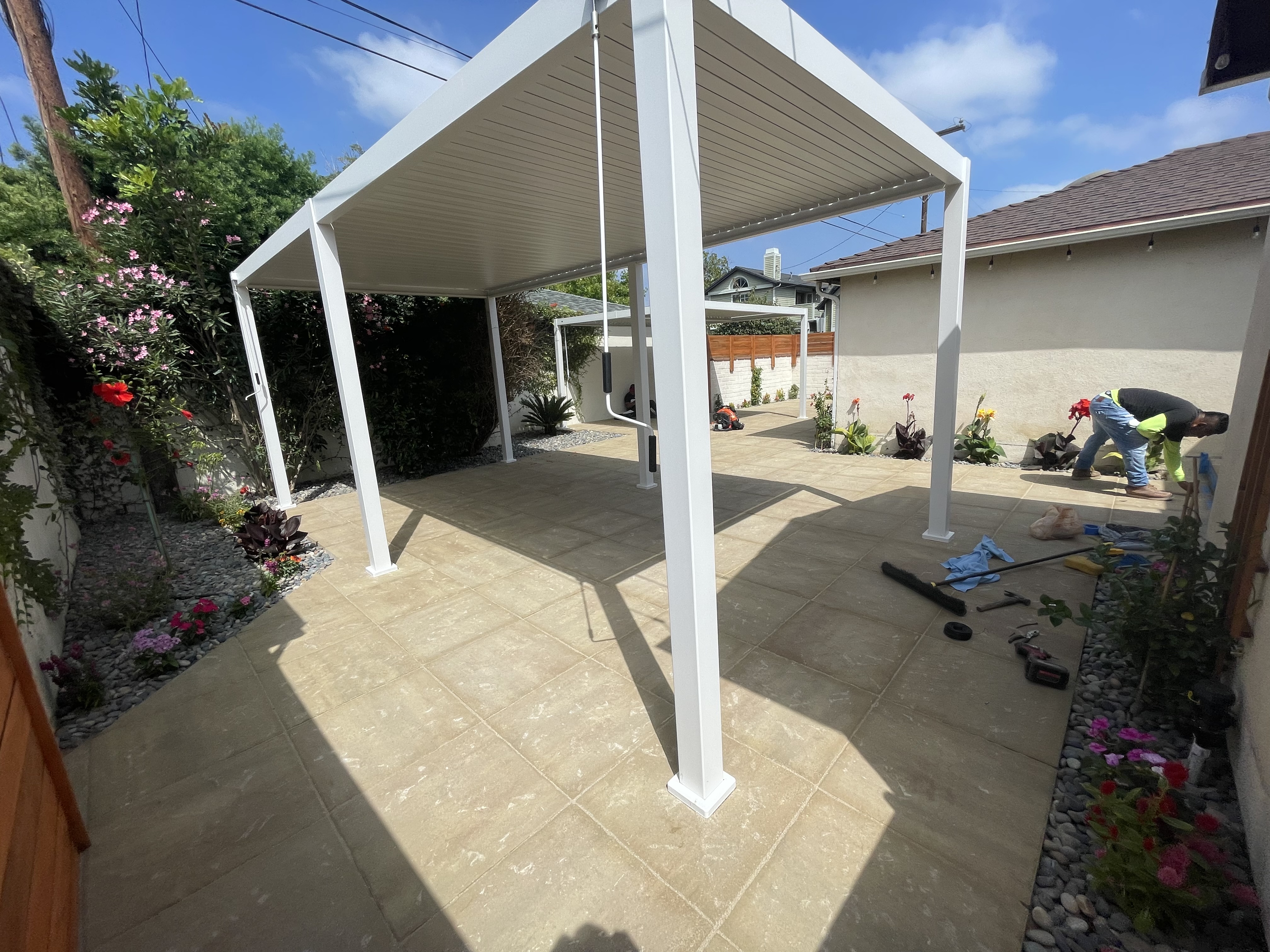 An outdoor patio with a covering designed by Green Design Builders